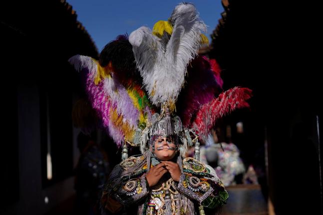 A dancer adjusts his costume before taking part in a procession honouring St Thomas, the patron saint of Chichicastenango, Guatemala.