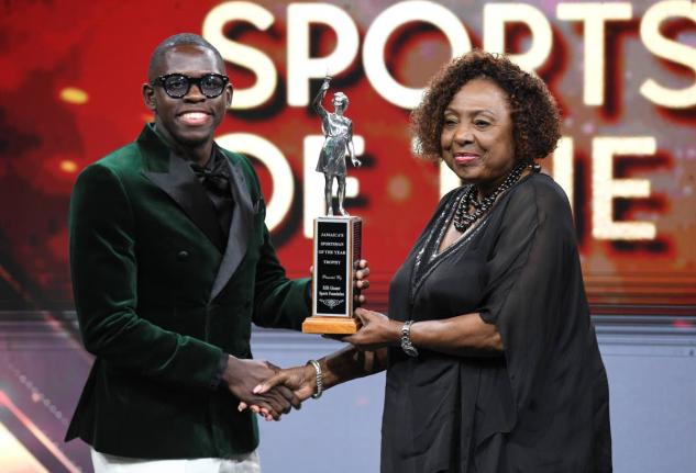 Oblique Seville receives the RJRGLEANER Sportsman of the Year award from Olivia ‘Babsy’ Grange, minister of culture, gender, entertainment and sport, during the RJRGLEANER National Sports Award on Saturday at the TVJ Studios.