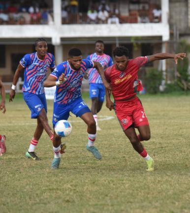 Portmore United’s Gawain Austin (left) and Montego Bay United’s Richardo Ramsey battle for the ball during their Jamaica Premier League game at Jarrett Park in Montego Bay yesterday. The game ended 0-0.