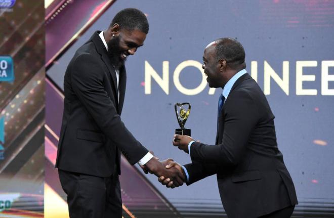 High jumper Raymond Richards (left) is presented with an award during the RJRGLEANER Communications Group National Sports Awards from Head of TV Business Ransford Ricketts at the TVJ Studios on Saturday. 