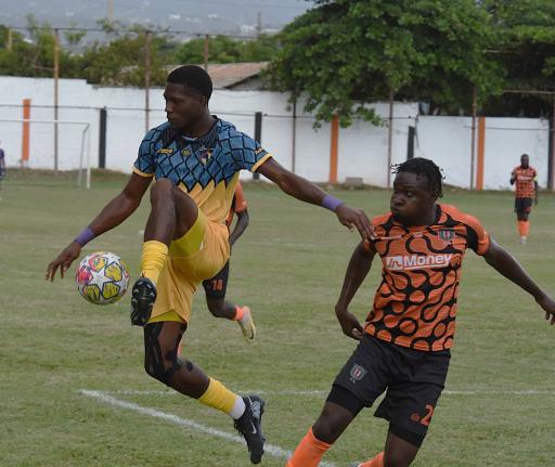 Racing United’s Jimoy Jones (left) intercepts a pass aead of Tivoli Gardens’ Dayne Ewen during their Jamaica Premier League football match at the Edward Seaga Stadium yesterday. The game ended 0-0.