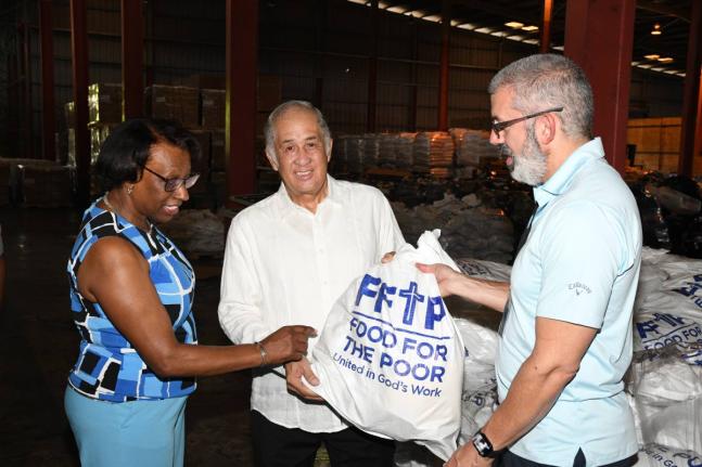 Paulette Simpson (left), executive, corporate affairs and public policy for the JN Group in the UK examines items shipped to Food for the Poor along with Chief Operating Officer of Food for the Poor, Mark Khouri (right) and Chairman of the JN Foundation, P