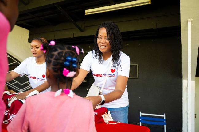 Celia Ebanks (right) and Gabriel Hall of the JMMB Joan Duncan Foundation distribute gift packages to children during this year’s children’s treat held at the Philip Sherlock Centre for the Creative Arts, UWI, Mona. This year, the Foundation hosted 158 