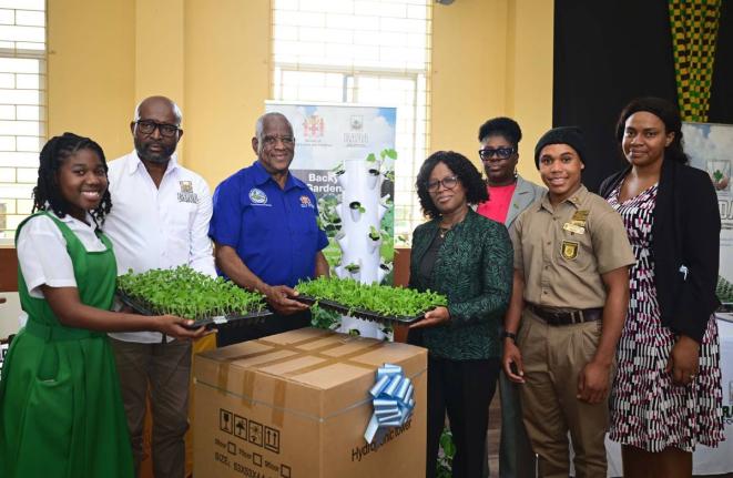 Minister of State in the Ministry of Agriculture, Fisheries and Mining, Franklyn Witter (third left), presents a vertical hydroponic tower to Vice-Principal of Manchester High School, Hillary Morgan (fourth left), during a ceremony held at the school on Ja