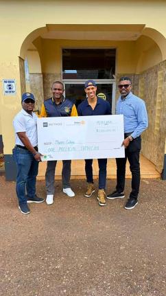 President of the Rotary Club of St Andrew North, Pierpont Wilson (left), hands over a cheque to Principal of Munro College, Dr Mark Smith (second left), at the school recently. Founder of KR Method, Korey Rowe (third left), and his brother, Past President 
