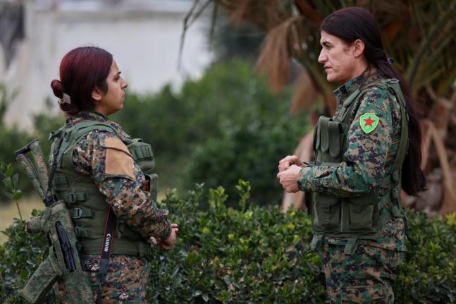 Rohlat Afrin, commander of the Syrian Democratic Forces (SDF) Women’s Protection Units, right, talks with a soldier in Qamishli, Syria.