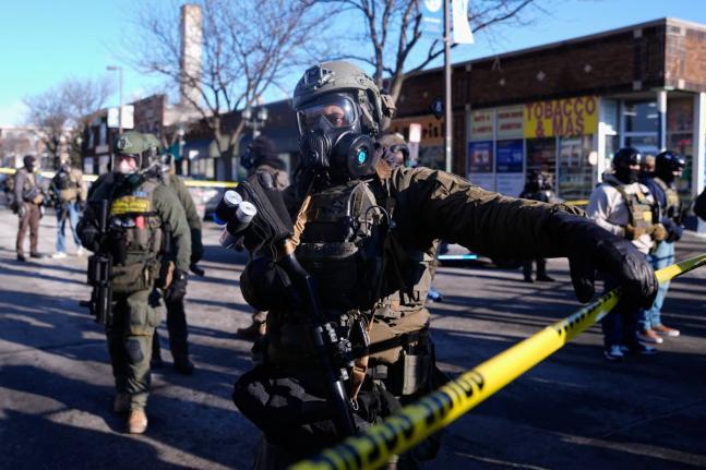Federal agents stand near the site of a shooting in Minneapolis.