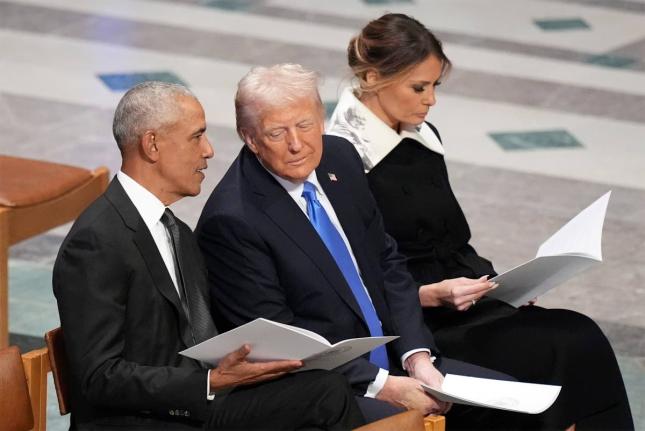 Former United States President Barack Obama talks with then President-elect Donald Trump as Melania Trump reads the funeral programme before the state funeral for former President Jimmy Carter at Washington National Cathedral in Washington on January 9, 20