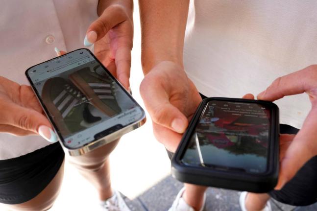 Young people use their phones to view social media in Sydney, Australia.
