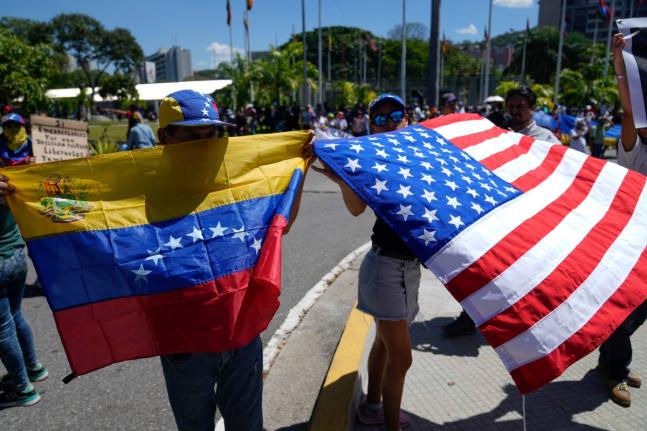 Demonstrators hold a Venezuelan and U.S. national flags during a student-led march calling for the release of people considered political prisoners on National Youth Day, in Caracas, Venezuela on February 12, 2026. 
