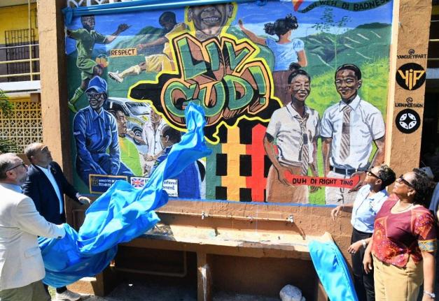 Christopher Tufton (second left), and Andrew Bowden (left), unveil the LIV GUD mural at Haile Selassie High School in Kingston, during the launch of the Wellness Express – Adolescent Mental Health Mobile Service. Looking on are Juliet Cuthbert Flynn (sec
