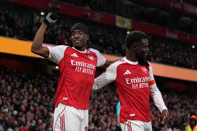 Arsenal’s Noni Madueke (left) and Bukayo Saka celebrate after their side’s first goal during the English FA Cup  match between Arsenal and Wigan Athletic in London yesterday.