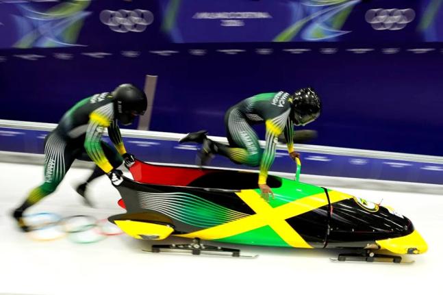 Jamaica’s Shane Pitter (right) and Junior Harris start for a two-man bobsled run at the 2026 Winter Olympics in Cortina d’Ampezzo, Italy, on Monday.