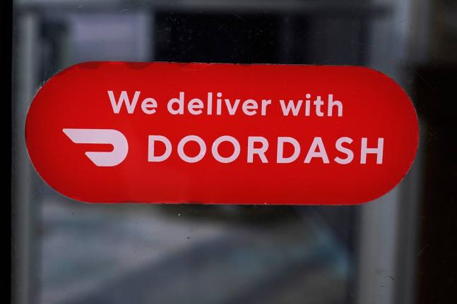 AP
A DoorDash sign is posted on the door of a Dunkin’ Donuts franchise in February 2023 in Methuen, USA.  