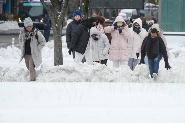 Pedestrians climb over snow banks to try and cross the streets in New York, Monday, January 26, 2026. (AP Photo/Seth Wenig, File)