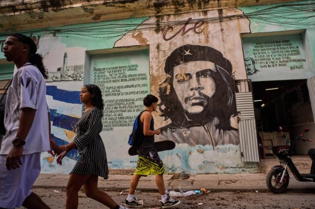 People walk past a mural of Che Guevara in Havana.