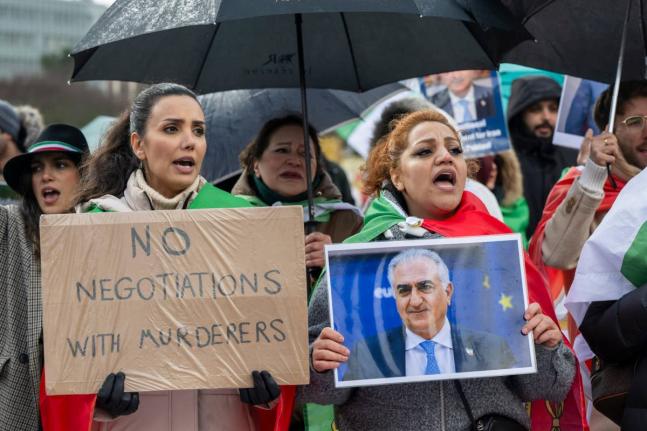 Iranian protesters hold placards and portraits as they demonstrate in front of United Nations office ahead of indirect nuclear talks between the United States and Iran in Geneva, Switzerland, on Tuesday, February 17.