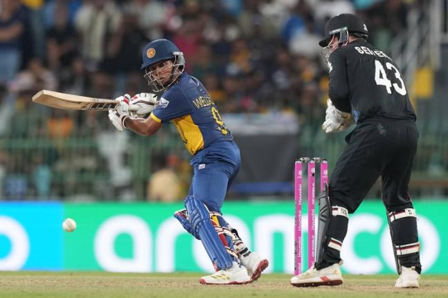 Sri Lanka’s Dunith Wellalage plays a shot during the T20 World Cup match against New Zealand in Colombo, Sri Lanka, yesterday. Looking on is New Zealand wicketkeeper Tim Seifert.