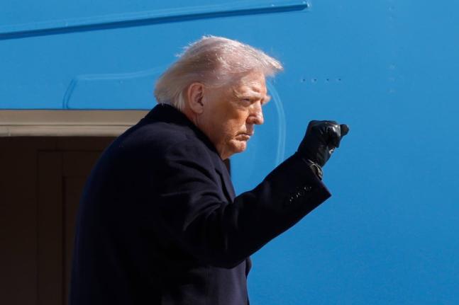President Donald Trump gestures from the stairs of Air Force One upon his arrival at Joint Base Andrews, Md., Friday, February 27, 2025. (AP Photo/Luis M. Alvarez)