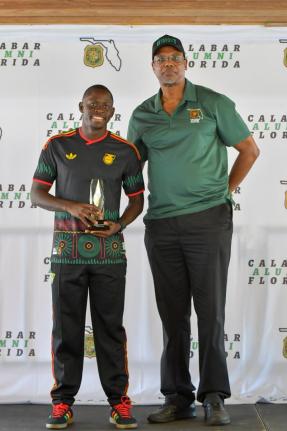 World 100 metres champion and Calabar old boy Oblique Seville (left) poses with his Lionheart Award for Courage. It was presented to him by Karl Thompson, president, Calabar Alumni Florida.