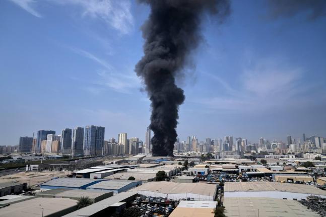 A black plume of smoke rises from a warehouse at the industrial area of Sharjah City in the United Arab Emirates following reports of Iranian strikes in Dubai, United Arab Emirates on Sunday.