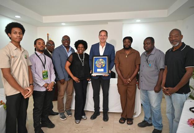 Hotelier Christopher Issa, owner and operator of S Hotels Jamaica, poses with a plaque he was honoured with by media members of the Western Jamaica Media Association (WJMA) on Sunday at Hotel 39 in Montego Bay. He is flanked by WJMA members. 