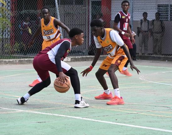 Herbert Morrison Technical High’s Antonio Kerr (left) tries to dribble around Manchester High’s Wasim Windett during Game 1 of the ISSA Schoolboys Under-16 Basketball finals at Herbert Morrison’s court on Monday, March 2.