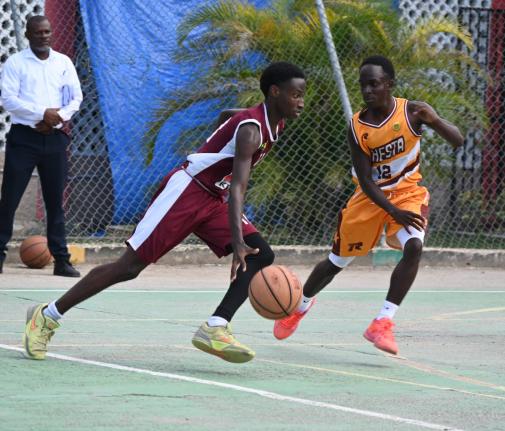 Herbert Morrison Technical High’s Michael Johnson (left) dribbles past Manchester High’s Waine Green Jr during game one of their ISSA Rural Schoolboy Under-16 Basketball finals at Herbert Morrison’s court on Monday, March 2.
