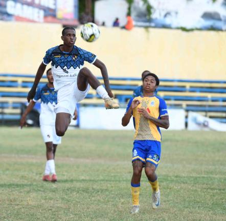 Giovanni Cunningham of Racing United FC controls the ball in the air as Geo Headley of Harbour View FC looks on during a Jamaica Premier League football match at the Harbour View Stadium in Kingston yesterday. Racing won 3-0. 