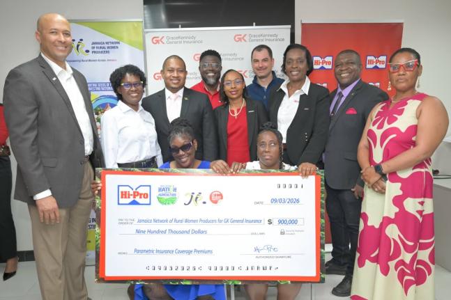 Minister of Agriculture, Fisheries and Mining,  Floyd Green (third left, second row), joins a photo opportunity as Hi-Pro presents a symbolic cheque to members of the Jamaica Network of Rural Women Producers (JNRWP) during the Roots Resilience Parametric I