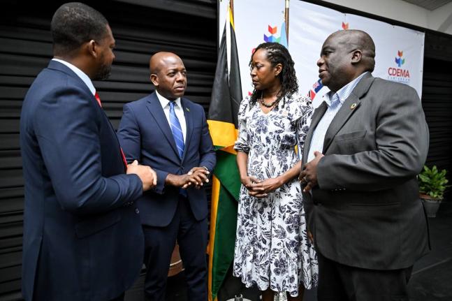 Minister of Labour and Social Security, Pearnel Charles Jr. (second, left), engages in a discussion with Director General at the Office of Disaster Preparedness and Emergency Management (ODPEM), Commander Alvin Gayle (left); Executive Director of the Carib