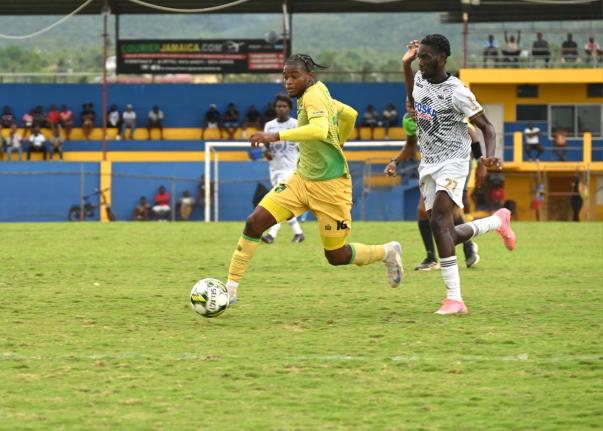 Navardo Blair (left) of Treasure Beach tries to outrun Cavalier’s  Jerome McLeary during their Jamaica Premier League game at St Elizabeth Technical Sports Complex yesterday. Cavalier won 1-0.
