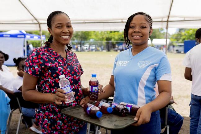 Sueann Ricketts (left), school nurse at St Catherine High School, poses for a photo with student Toronary Walker as they distribute refreshments during the school’s Sports Day activities on Thursday, March 12. St Catherine High School was one of the late