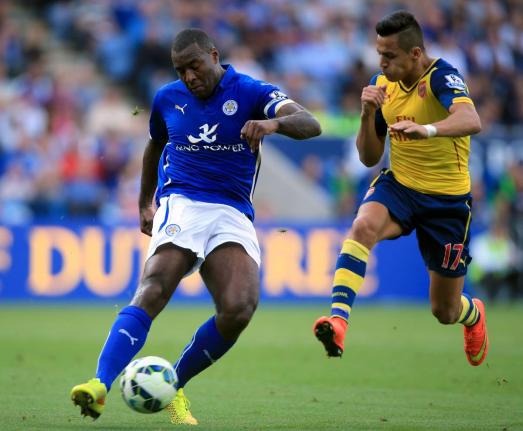 Leicester City’s Wes Morgan plays a pass as he comes under pressure from Arsenal’s Alexis Sanchez (right), during their English Premier League football match at the King Power Stadium, Leicester, England, Sunday, August 31, 2014. 