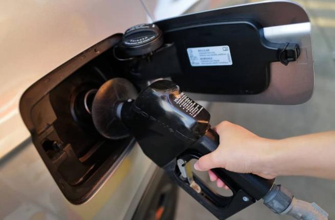 A person fills up her vehicle's gas tank at a gas station in Buffalo Grove, Ill., Thursday, March 19, 2026. 