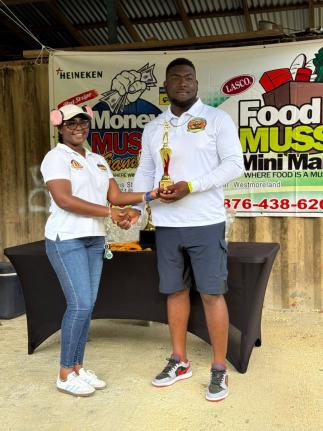 Ramiesh Williams, winner of the David McMorris Cup, collecting his championship trophy  from Karrell Scott, chief executive officer of Money Muss  Games and Bar. 