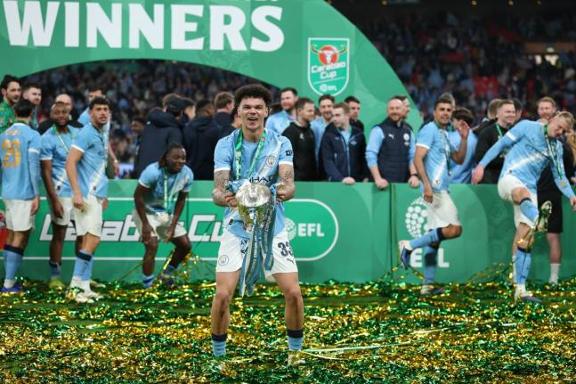 Manchester City’s Nico O’Reilly celebrates with the trophy after his team won the English League Cup final match against Arsenal at Wembley Stadium in London yesterday.