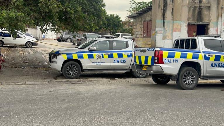 Police vehicles parked at a parking lot near Kingston Public Hospital, where officers are investigating a fatal shooting on March 25, 2026. 