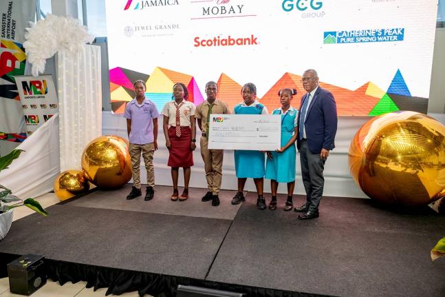 Saluting commitment and endurance: Senator Charles Sinclair (right) shares a photo op with a group of secondary awardees after presenting them with the symbolic cheque for J$30 million during the MBJ Foundation’s Charity Run/Walk Grant Award Ceremony at 