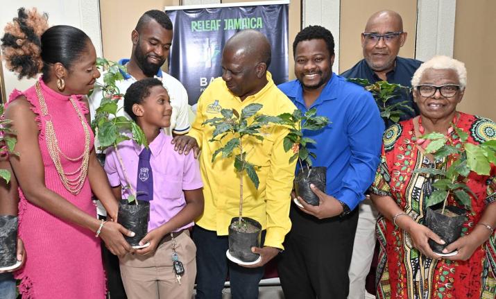 Young cricketer Se’andre Annick Wisdom, (second left) of Ascot Primary School is delighted to accept a coffee seedling as he stands alongside (from left) Andrea Hanson, chairman  of Portmore Sports Association; Aaron Johnson, founder of Blue 52 T20 Relea