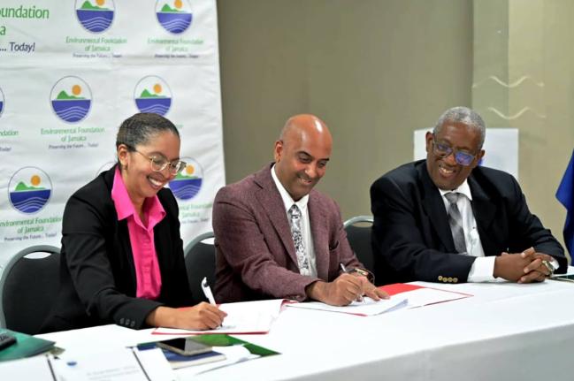 From left: Nicole Adamson, CEO of the EFJ, and Dr. Kishan Khoday, UNDP resident representative, ink the new agreement while Prof. Dale Webber, chairman of the EFJ, shares in the moment.