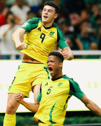 Reggae Boyz players Bailey Cadamarteri (left) and Richard King celebrate the former’s 18th-minute goal during a FIFA playoff game against New Caledonia at the Guadalajara Stadium last week.