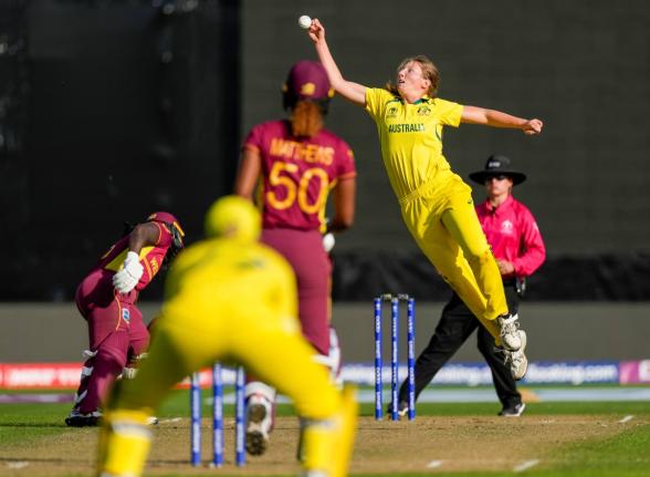 Darcie Brown of Australia (second right) attempts to field off her own bowling to the West Indies’ Hayley Matthews during the first semifinal match of the Women’s Cricket World Cup in Wellington, New Zealand on Wednesday, March 30, 2022. 