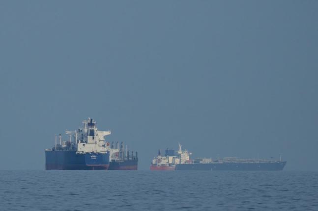 Oil tankers and cargo ships line up in the Strait of Hormuz, as seen from Khor Fakkan, United Arab Emirates.