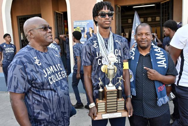 From left: Wayne Robinson, principal of Jamaica College, Michael-Andre Edwards, captain, and Duane Johnson, head coach, join in the celebration of the school’s ISSA/GraceKennedy Boys and Girls’ Athletics Championships at the institution’s Old Hope Ro