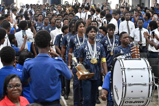 With hair of varying styles and lengths, Jamaica College students celebrating their victory in the ISSA/GraceKennedy Boys’ Athletics Championships last month.