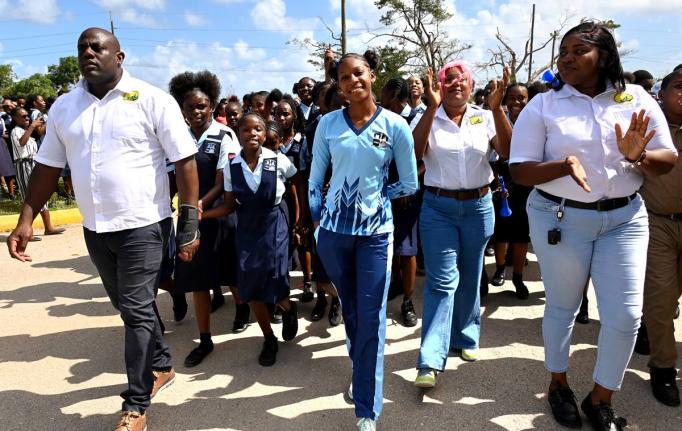 Shanoya Douglas (centre) enters Holland High School grounds in Trelawny to a hero’s welcome on Monday, following her record-breaking performance at the 2026 ISSA GraceKennedy Boys’ and Girls’ Athletics Championships.