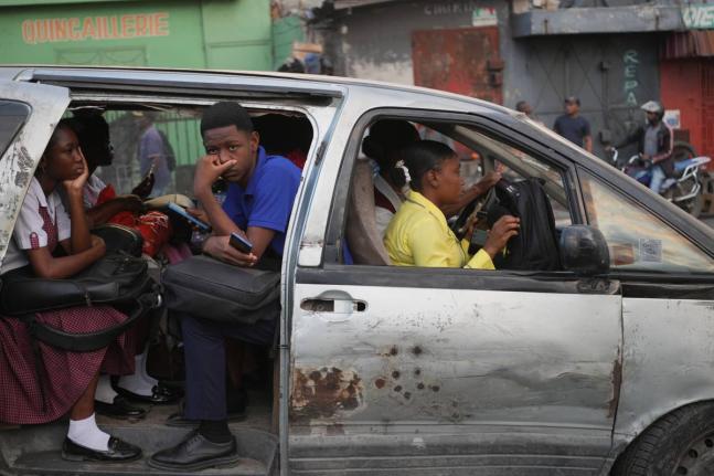 Passengers ride in a shared taxi as it makes its way through Port-au-Prince, Haiti, Wednesday, March 25, 2026. (AP Photo/Odelyn Joseph)