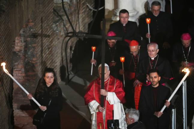 Pope Leo XIV carries a lightweight, 1.5-meter (5-foot) wooden cross during the Via Crucis, the torchlit Good Friday Stations of the Cross procession at the Colosseum in Rome, which symbolically retraces Jesus Christ’s steps to his crucifixion on Calvary 