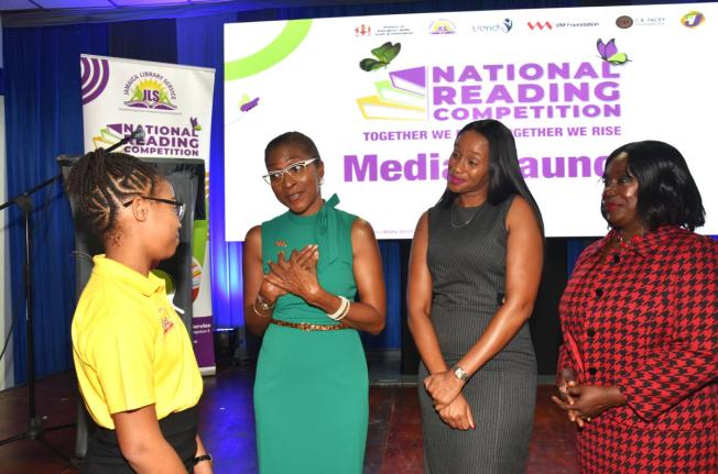 State Minister, Ministry of Education, Skills, Youth and Information,  Rhoda Moy Crawford (second right), listens as CEO of VM Foundation, Samantha Charles (second left), makes a point to Jamaica Library Service (JLS) National Reading Competition 2025 winn